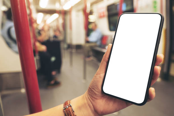 istock woman's hands holding black mobile phone with blank screen in subway 1152333331