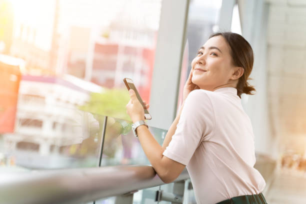 istock Happy woman using smart phone in the city 1152338810