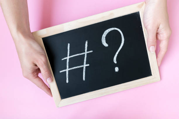 istock Female hands holding a blackboard with a chalk hashtag and a question mark written on it. 1152338881