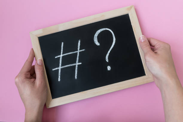 istock Female hands holding a blackboard with a chalk hashtag and a question mark written on it. 1152338882