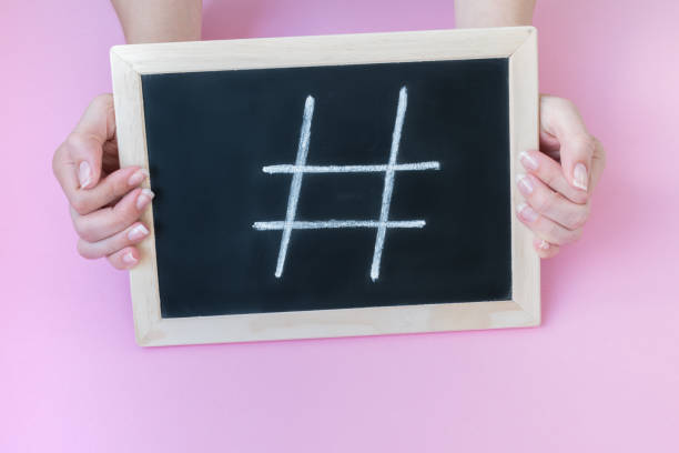 istock Female hands holding a blackboard with a chalk hashtag written on it. 1152338884