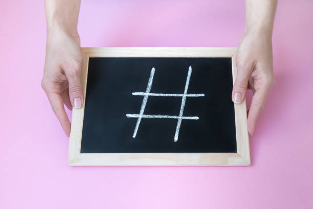 istock Female hands holding a blackboard with a chalk hashtag written on it. 1152338886