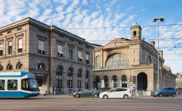 Building of the Zurich main railway station Zurich, Switzerland - October 25, 2017: partial view of the building of the Zurich main station, slightly blurred due to their motion cars in front of it. Zurich main station (German: Zurich Hauptbahnhof) is the largest railway station in Switzerland. zurich train station stock pictures, royalty-free photos & images