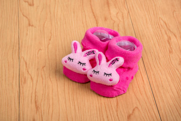 istock baby socks in wooden background 1152342434
