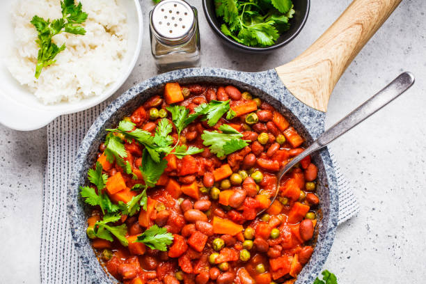 istock Vegan bean stew with tomatoes and rice in a pan over white background. 1152342696