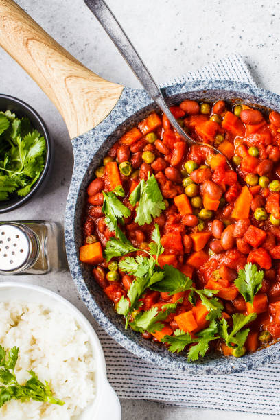 istock Vegan bean stew with tomatoes and rice in a pan over white background. 1152343450