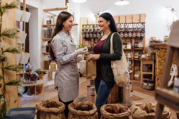 istock Smiling shopkeeper helping customer in packaging free shop. 1152345370