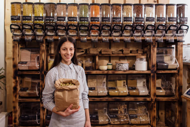 Portrait of smiling shopkeeper in package free grocery store. stock photo