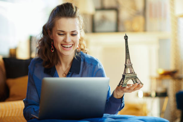 istock happy modern woman with souvenir of eiffel tower using laptop 1152346411