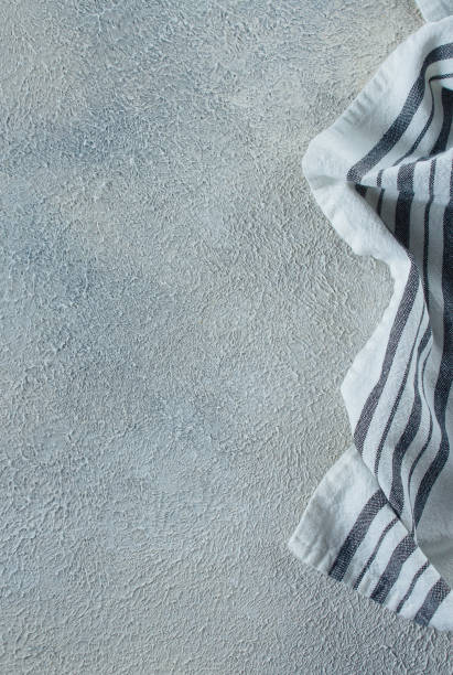 istock Light kitchen towel with blue stripe on blue stone concrete background. Place for text, object. Top view 1152348422