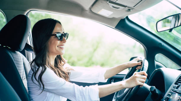 carino giovane successo felice bruna donna è alla guida di un'auto - solo ragazze foto e immagini stock