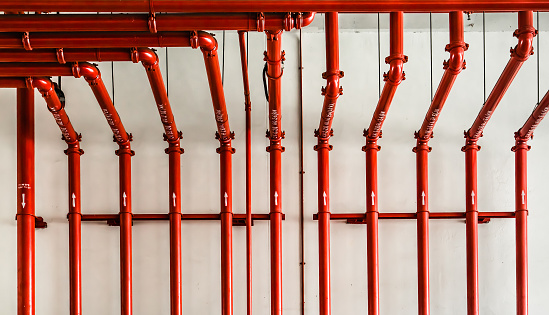 red metal pipe on white wall