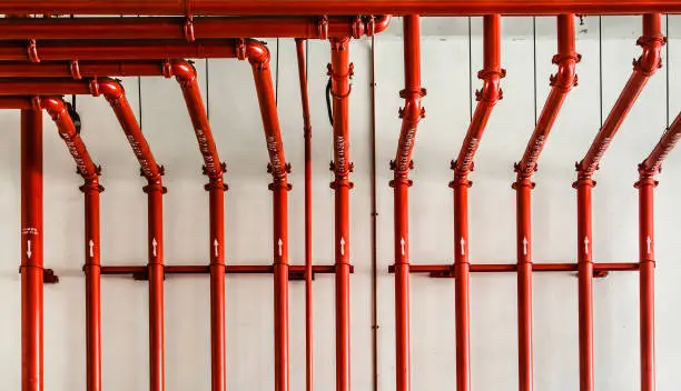 Photo of red color metal pipe on white wall