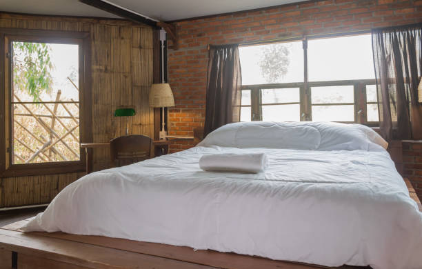 белая кровать в спальне дизайн интерьера номер в стиле кантри-лофт - antique bed стоковые фото и изображения