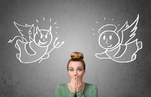 istock Woman standing between the angel and the devil 1152351431