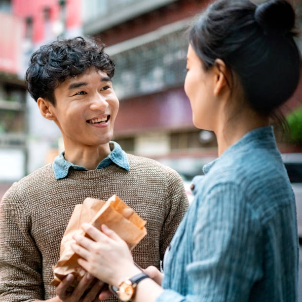 istock Couple holding food while standing in city 1152351531