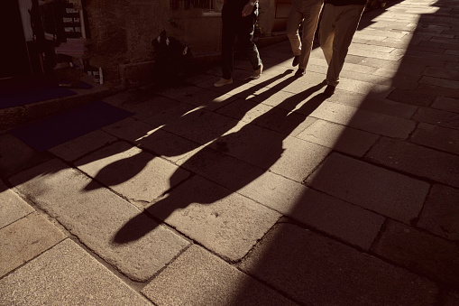 A shadow of two people walking on the sidewalk