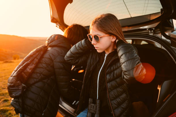 istock Mother and daughter sitting on car trunk on a mountain 1152365679