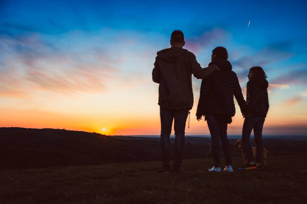 istock Family with dog embracing while standing on the hill 1152366137