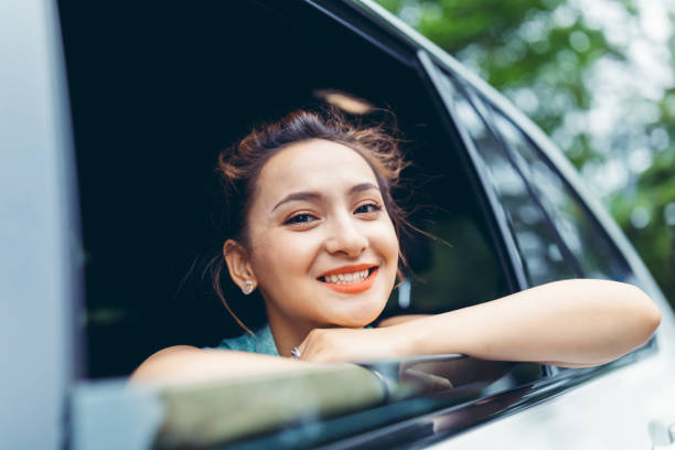 istock Businesswoman smiling and looking at camera inside a car 1152369795