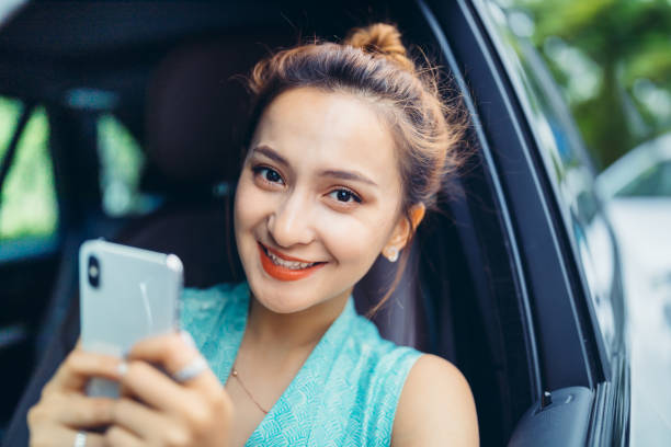istock Businesswoman using smart phone in a car 1152369841