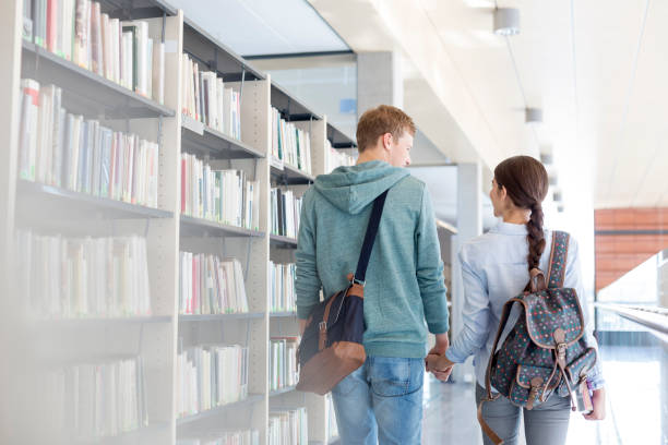 istock Rear view of couple walking while holding hands in library 1152370661