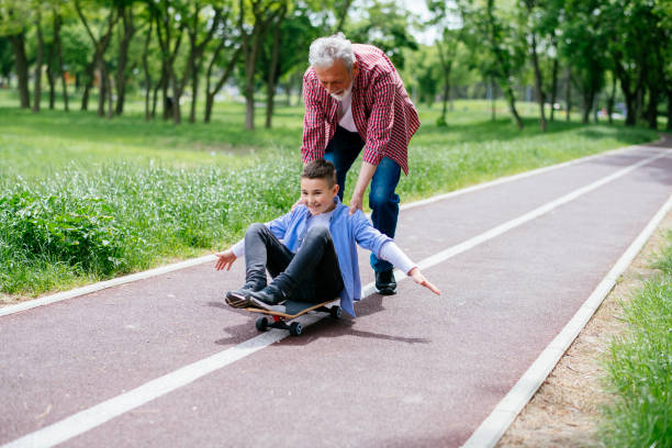 istock Grandfather and grandson skateboarding together 1152372149