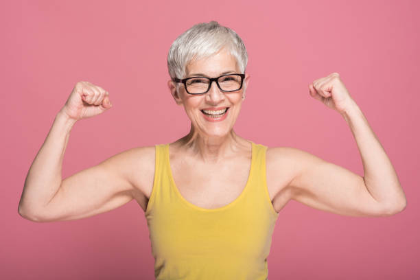 woman flexing muscles - flexing muscles fotos imagens e fotografias de stock