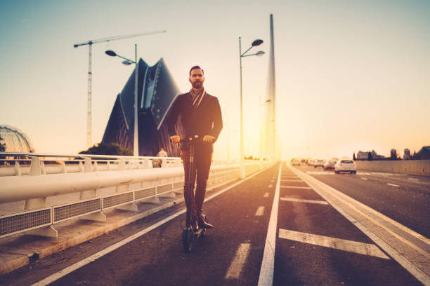 Businessman riding scooter at evening