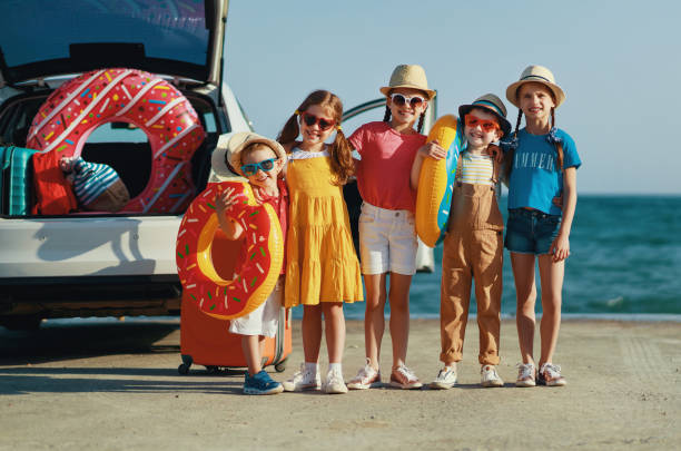 groupe heureux enfants filles et garçons amis sur le trajet en voiture à l’été voyage - people child twin smiling photos et images de collection