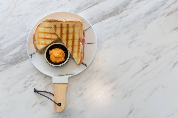 kanapka z serem szynkowym z sosem kremowym na marmurze - breakfast bread table drop zdjęcia i obrazy z banku zdjęć