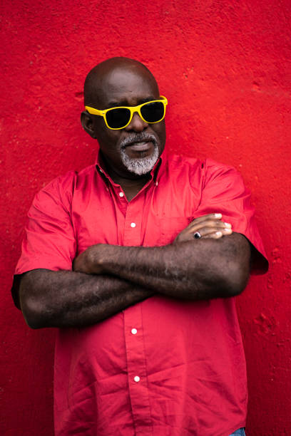 istock Man with yellow sunglasses standing arms crossed 1152377211