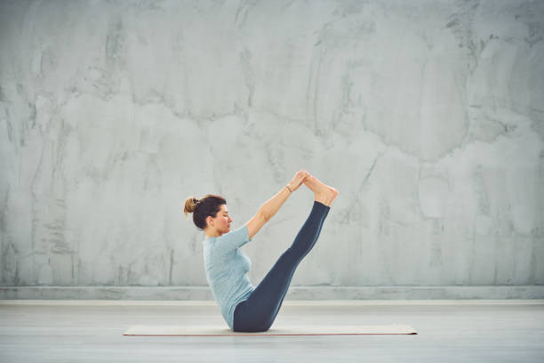 istock Woman sitting in boat yoga pose. 1152377260