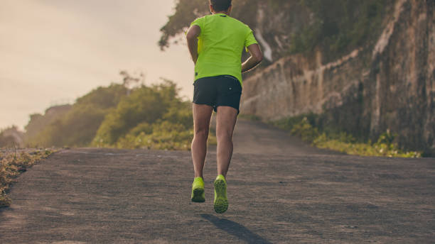 istock Man jogging on a downhill / uphill in suburb mountain road. 1152378926