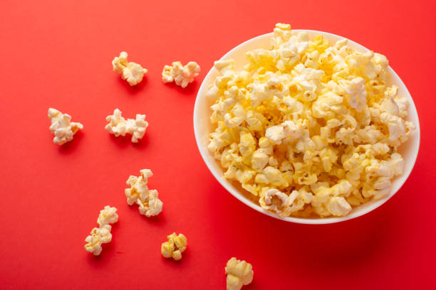 istock plate with popcorn on a red bright background. movie viewing concept, weekend getaway, with space 1152379838