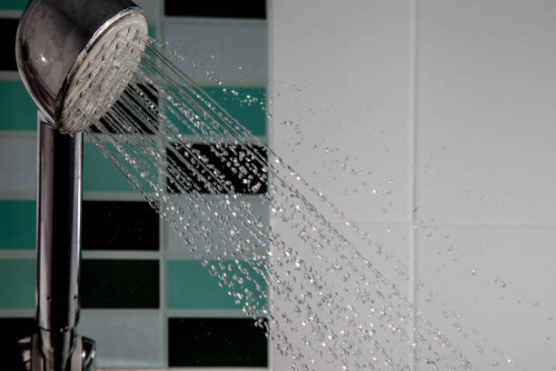 istock Shower head splashing water with water drops flowing in bathroom. 1152380045