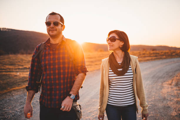 istock Happy hiking couple on a dirt road during sunset 1152380558