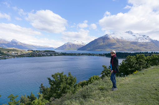 A young men enjoying the beautiful view of lake wakatipu, New Zealand