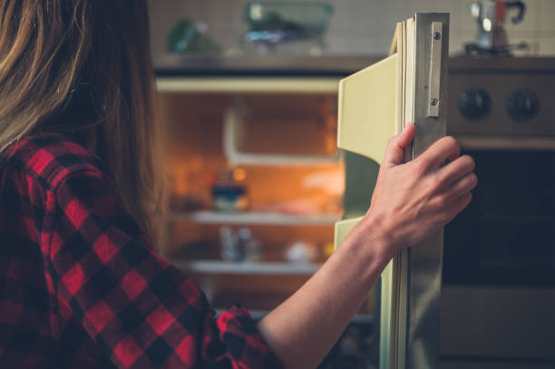 istock Young woman opening her fridge 1152384635