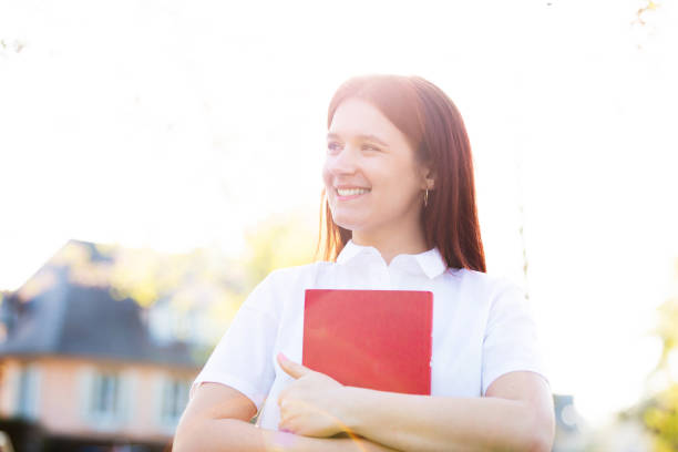 istock Holding a red book over sunny background 1152386509