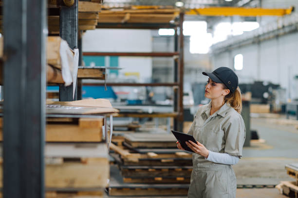 istock Female quality control worker working at large factory warehouse. 1152388054