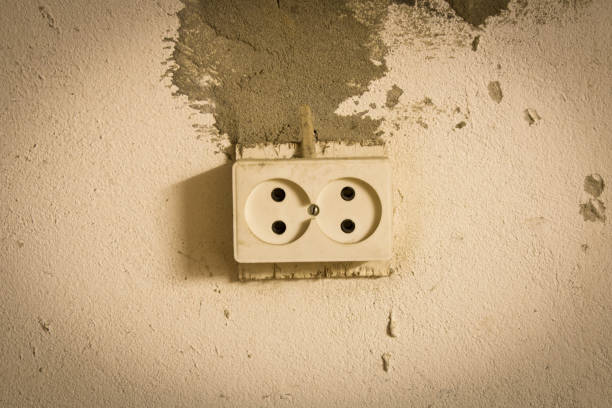 istock Electrical outlet on the old concrete wall. Isolated on light background. 1152388914