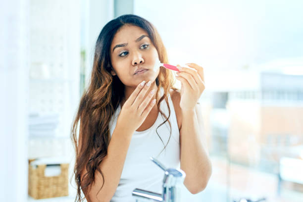 Getting rid of unwanted hair Cropped shot of a beautiful young woman shaving her facial hair at home facial hair stock pictures, royalty-free photos & images