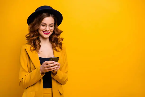 Close up photo beautiful amazing she her toothy lady arms hands telephone perfect look red lips pomade reader fashion news wear specs formal-wear costume suit isolated yellow vivid vibrant background.