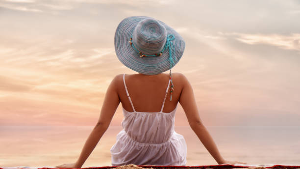 istock female sitting relax on beach by sea with sunset sky 1152391096