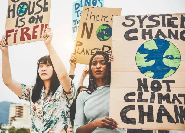 Photo of Group of demonstrators on road, young people from different culture and race fight for climate change - Global warming and enviroment concept - Focus on afro girl face