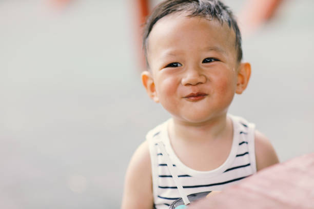 One year old boy smiling portrait in the park