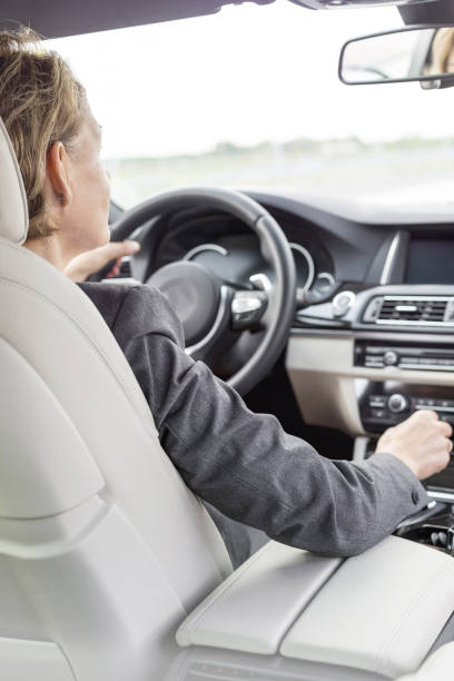 istock Female executive driving car during business trip 1152395796