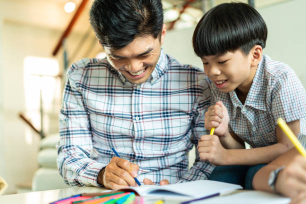 istock Father helping son with homework at home 1152395996
