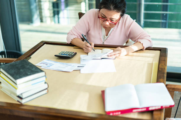 istock Senior female accountant calculating finances 1152396083